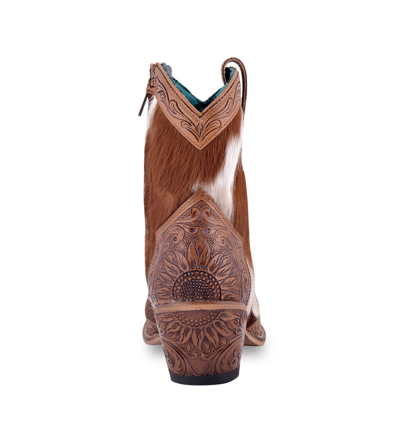 White and brown cowgirl boots with embossed floral patterns on the toe and heel areas