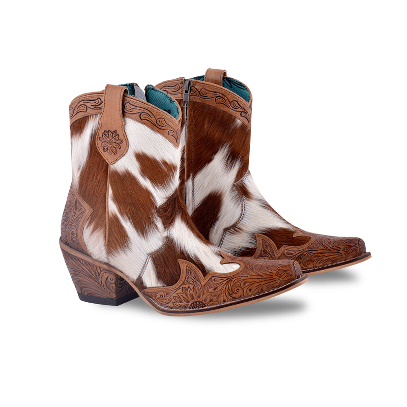 White and brown cowgirl boots with embossed floral patterns on the toe and heel areas