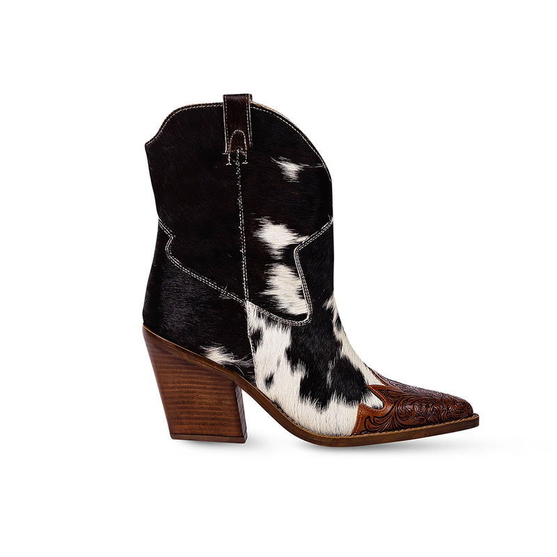 Cowgirl boots with a pointed toe and a mid-height heel featuring black and white cowhide leather