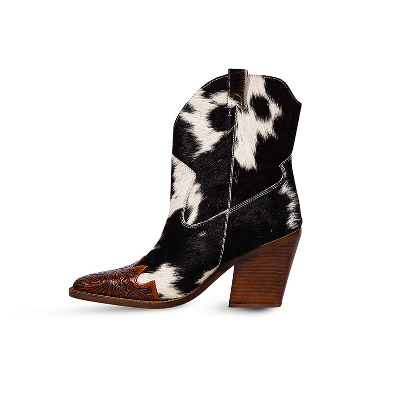 Cowgirl boots with a pointed toe and a mid-height heel featuring black and white cowhide leather