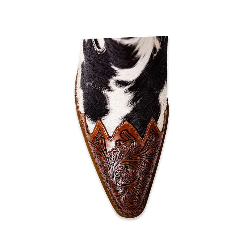 Cowgirl boots with a pointed toe and a mid-height heel featuring black and white cowhide leather