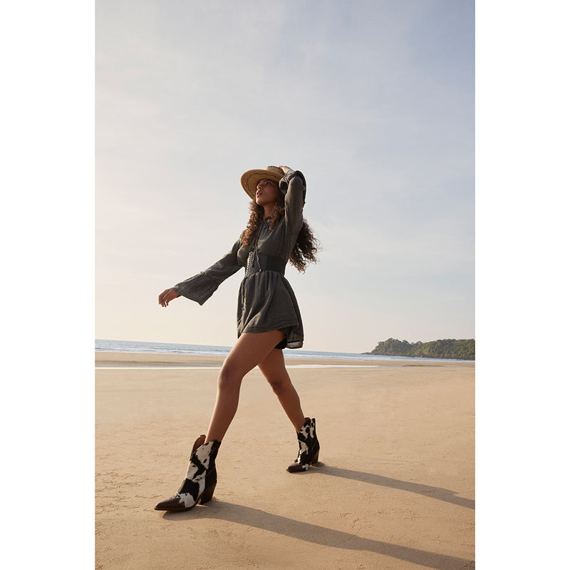 Cowgirl boots with a pointed toe and a mid-height heel featuring black and white cowhide leather