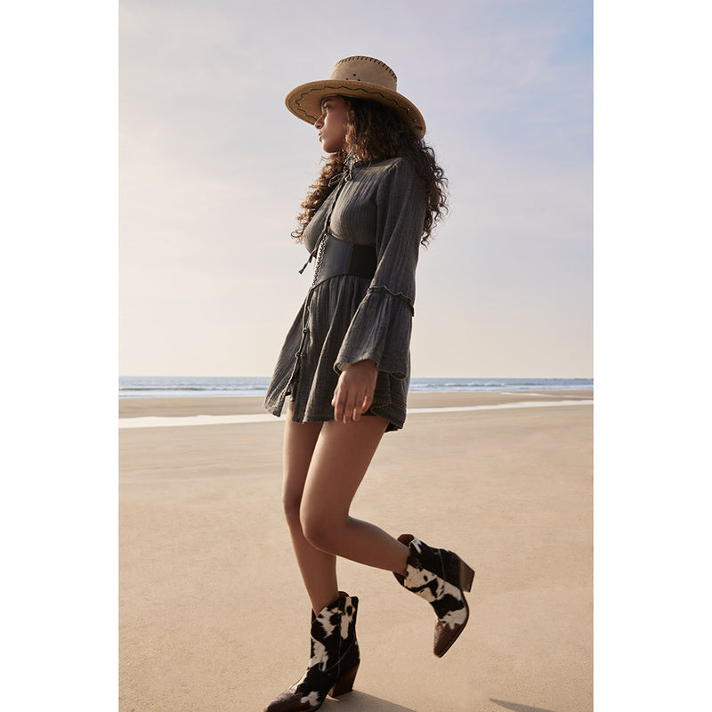 Cowgirl boots with a pointed toe and a mid-height heel featuring black and white cowhide leather