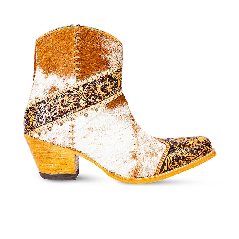 Cowgirl boots with golden floral patterns embossed on the front