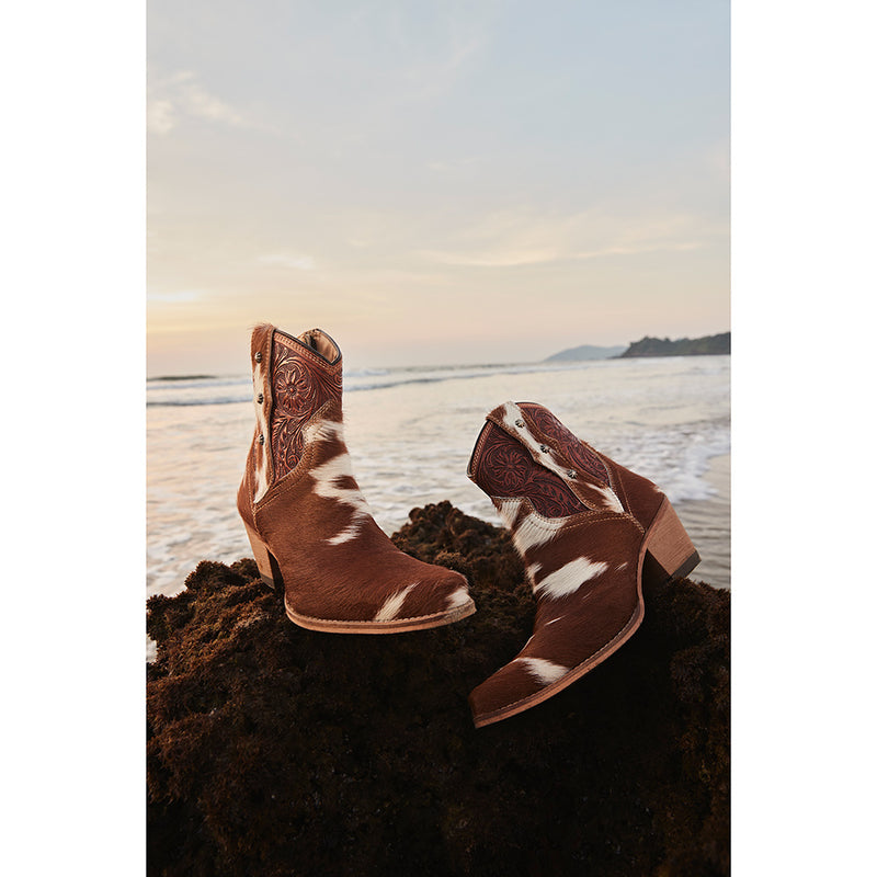 Brown and white cowhide & hand tooled western boots with slightly elevated heels and pointed toes