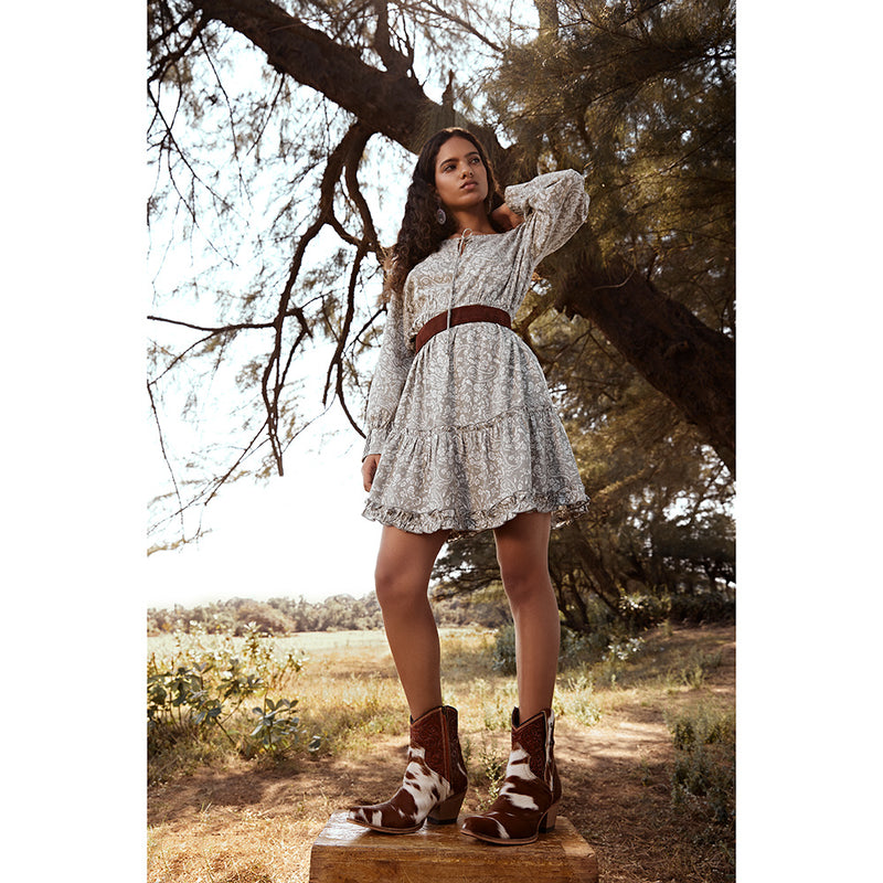 Brown and white cowhide & hand tooled western boots with slightly elevated heels and pointed toes