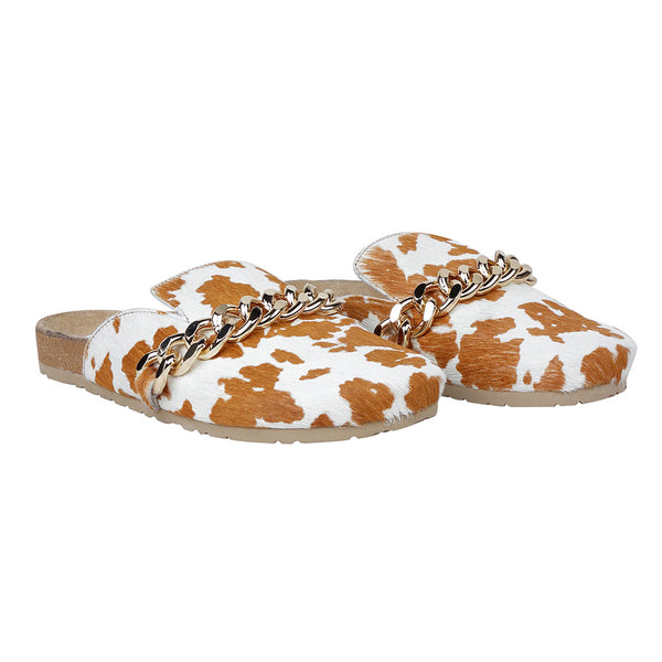 Brown and white cowhide slip-on slippers with golden chain detailing on the upper