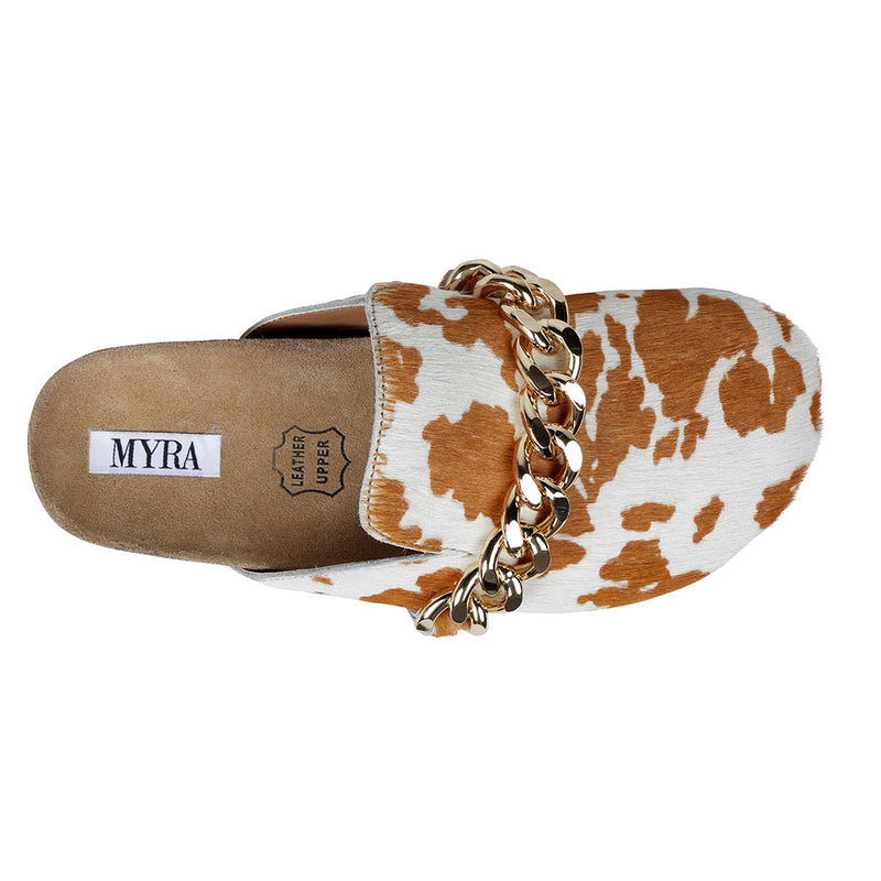 Brown and white cowhide slip-on slippers with golden chain detailing on the upper