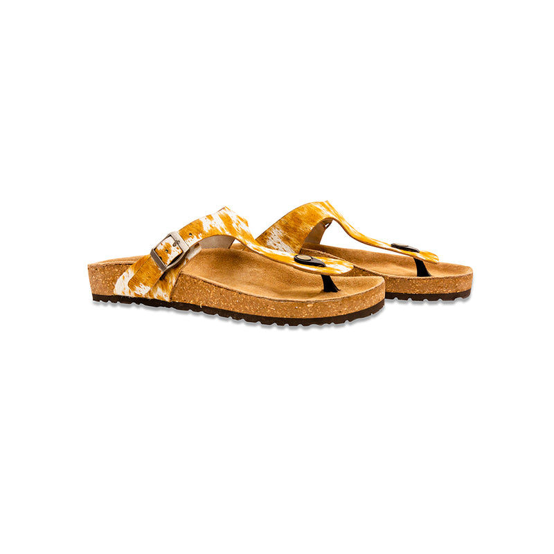 Handtooled sandals with a cork footbed and a rubber sole. Brown and white straps made with hairon leather