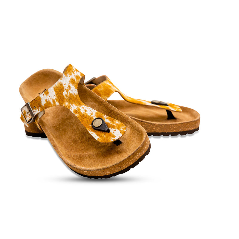 Handtooled sandals with a cork footbed and a rubber sole. Brown and white straps made with hairon leather